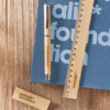 Set di Gadget in bambù promozionali Animalis Foundation: penna, righello e chiavetta USB su quaderno blu.