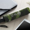 Ombrelli stampati all-over pieghevoli personalizzato con stampa all-over mimetica verde e logo OLAF Northwear su una scrivania.