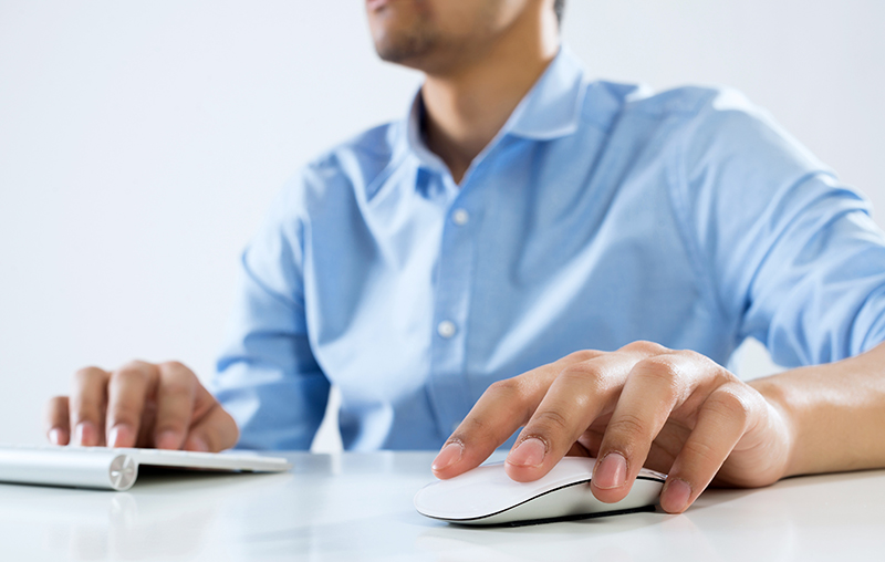 Professionista in camicia azzurra che utilizza mouse e tastiera per la gestione di ordini e consulenza gadget personalizzati pro&motion.
