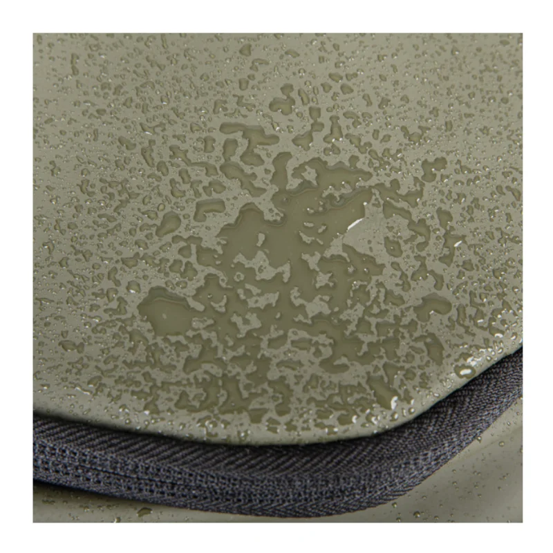 Primo piano del tessuto PU waterproof dello zaino con gocce d'acqua sulla superficie.