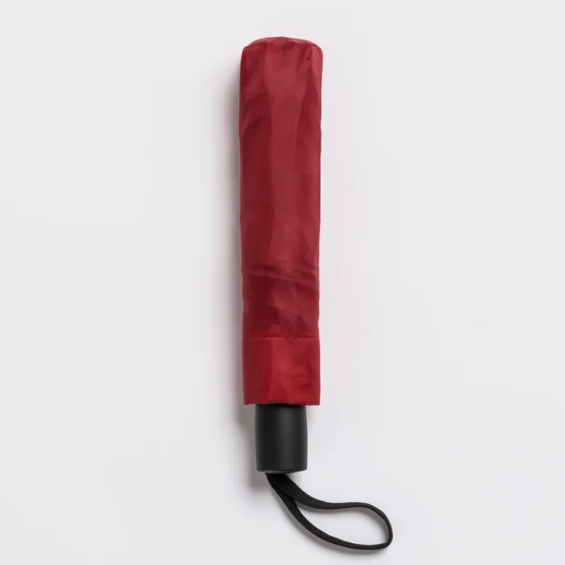 Ombrello automatico compatto chiuso di colore rosso, facile da trasportare.